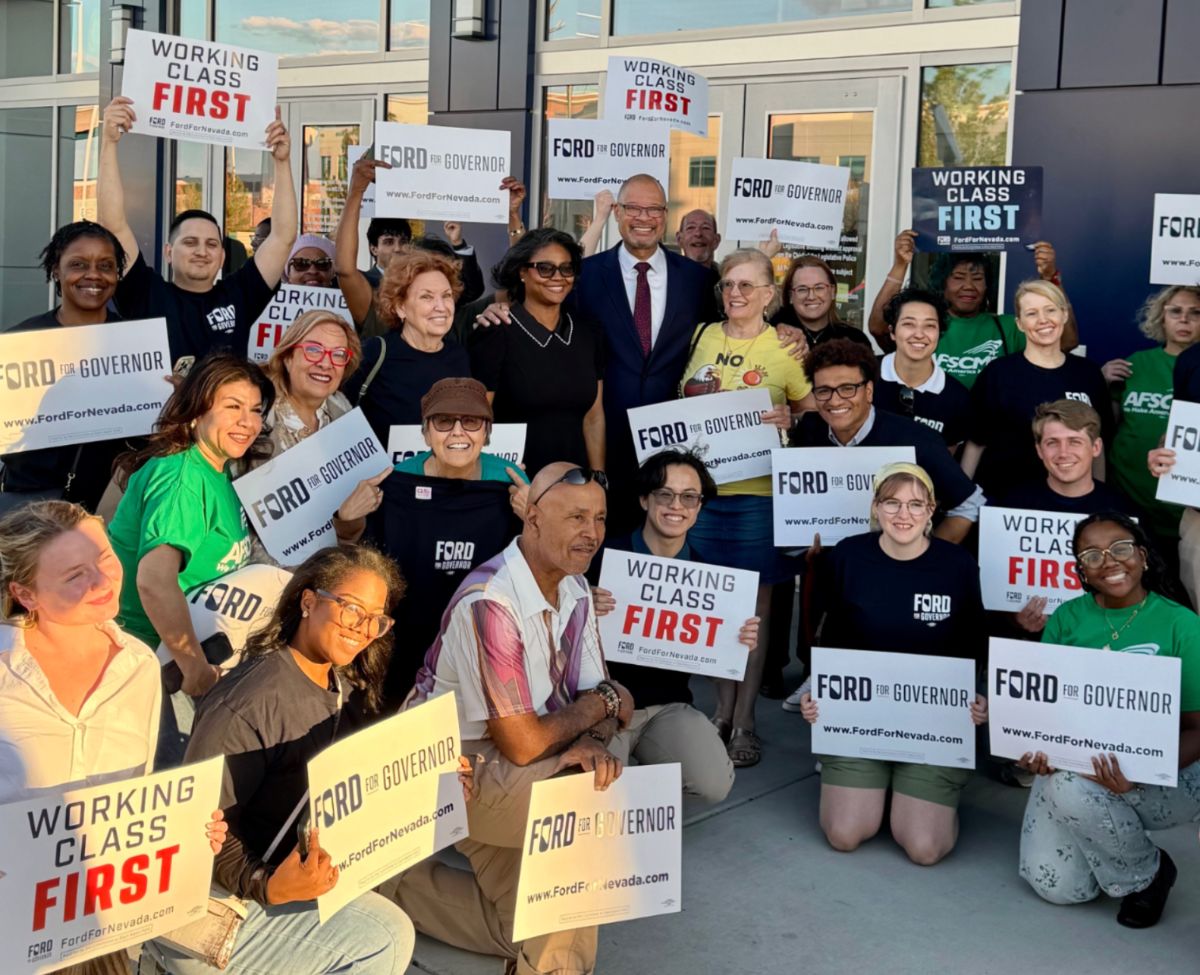 Aaron standing with a group of Nevadans holding up 'Working Class First' signs